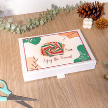 Load image into Gallery viewer, Decorative box with 'Enjoy the Moment' text on a wooden surface with greenery and scissors.