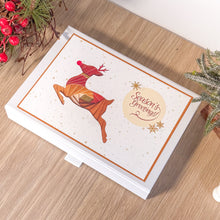 Load image into Gallery viewer, Christmas card with reindeer design and 'Season's Greetings!' text on a wooden surface.