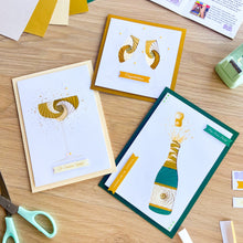 Load image into Gallery viewer, Three greeting cards with celebratory iris fold designs on a wooden surface.