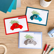 Load image into Gallery viewer, Three Christmas-themed iris fold car greeting cards on a wooden surface with stationery items.