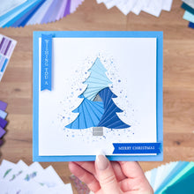 Load image into Gallery viewer, Blue Christmas tree card held by a hand with color swatches in the background