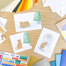 Load image into Gallery viewer, Collection of cat card apertures on a wooden surface with color swatches.