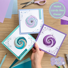 Load image into Gallery viewer, Handmade cards with spiral designs on a wooden table with craft supplies.