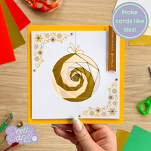Load image into Gallery viewer, Handmade card with decorative design on a wooden table with craft supplies.