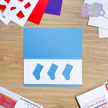 Load image into Gallery viewer, three stocking aperture on blue card