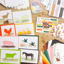 Load image into Gallery viewer, Kit contents featuring the animal cut-out apertures, card blanks and papers