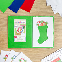 Load image into Gallery viewer, Christmas-themed card with a green stocking design on a wooden surface