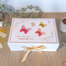 Load image into Gallery viewer, White box with butterfly design and message on a wooden surface with plants and a mug.