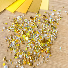 Load image into Gallery viewer, Gold and white gem pearl embellishments scattered on a wooden surface with yellow paper in the background