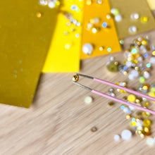 Load image into Gallery viewer, close up of gold pearl held by tweeers