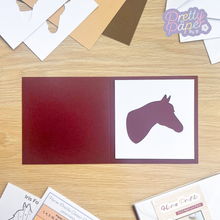 Load image into Gallery viewer, Horse aperture on maroon card blank