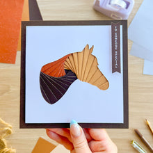 Load image into Gallery viewer, A hand holds a square greeting card featuring an iris fold horse head made of layered fan-like paper shapes in tan, orange, and dark brown. The card has a white center, a dark brown border, and a vertical label reading 'TO SOMEONE SPECIAL.