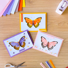 Load image into Gallery viewer, Three iris fold emperor butterfly greeting cards on a wooden table with craft supplies.