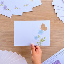 Load image into Gallery viewer, A hand holding a mini butterfly card aperture with printed blue flowers