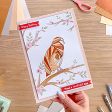 Load image into Gallery viewer, Hand holding a birthday card with a tawny owl design on a wooden surface.