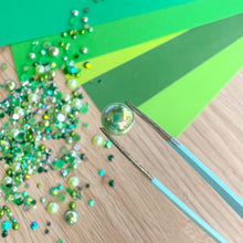 Load image into Gallery viewer, Green pearl on a wooden surface with tweezers and green paper