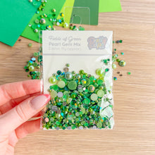Load image into Gallery viewer, Packaged green pearl gem mix held by a hand on a wooden surface