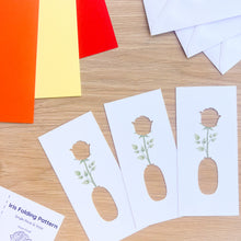 Load image into Gallery viewer, three rose and vase apertures with printed stems on a wooden surface with card blanks and envelopes