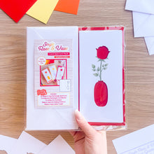 Load image into Gallery viewer, Card aperture pack with a rose and vase design on a wooden surface