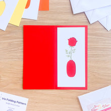 Load image into Gallery viewer, Red card with a rose aperture on a wooden surface