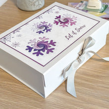 Load image into Gallery viewer, Gift box with purple snowflakes and 'Let it Snow' text on a wooden surface