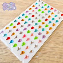 Load image into Gallery viewer, Sheet of colorful gem stickers on a clear backing with 'Pretty in Paper by B' branding.