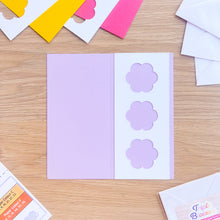 Load image into Gallery viewer, Purple card with flower aperture on a wooden surface