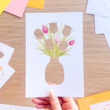 Load image into Gallery viewer, Card with tulip aperture design held by a hand on a wooden surface