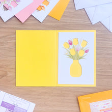 Load image into Gallery viewer, Bright yellow card blank with tulip aperture on a wooden surface