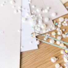 Load image into Gallery viewer, close up of a white crystal gem held by tweezers