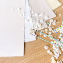 Load image into Gallery viewer, Close-up of pearls and tweezers on a wooden surface with a blurred background