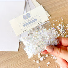 Load image into Gallery viewer, Pearl gem mix packaging with hand holding some gems on a wooden surface