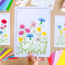 Load image into Gallery viewer, Colourful iris folding flower picture with paper craft supplies on a wooden surface