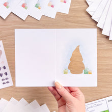 Load image into Gallery viewer, A baby gonk card cut-out embellished with presents in green and gold
