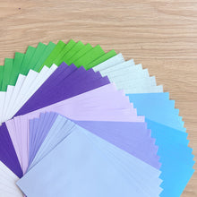 Load image into Gallery viewer, Assorted colorful paper sheets on a wooden surface
