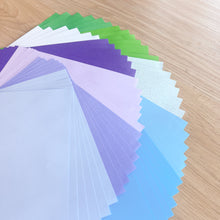 Load image into Gallery viewer, Color swatch card with various colored paper sheets on a wooden surface
