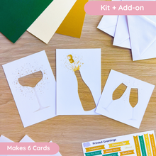 Load image into Gallery viewer, champagne cut-outs with card blanks and envelopes on a wooden surface
