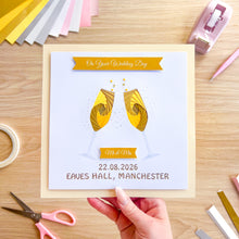 Load image into Gallery viewer, Wedding design in gold and white held by a hand on a wooden surface with craft supplies.
