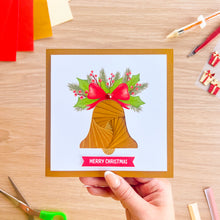 Load image into Gallery viewer, A greeting card with an iris fold bell in gold with a printed red bow and green holly leaves and a 'Merry Christmas' greeting.
