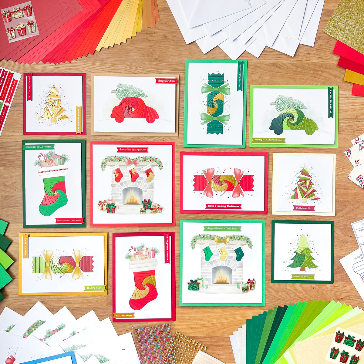 Collection of Christmas-themed iris folded greeting cards on a wooden surface with additional craft materials.