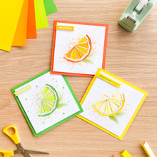 Load image into Gallery viewer, Three iris folding greeting cards with citrus fruit designs on a wooden surface with craft supplies.

