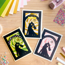 Load image into Gallery viewer, Three iris fold greeting cards on a wooden surface with decorative elements.
