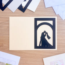 Load image into Gallery viewer, Cream card with a cut-out design of a couple kissing on a wooden surface
