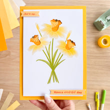 Load image into Gallery viewer, Greeting card with yellow daffodil flowers and text on a wooden surface
