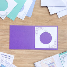Load image into Gallery viewer, Purple card with round design on a wooden surface
