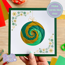 Load image into Gallery viewer, Handmade card with green and gold spiral design held by a hand on a wooden surface.
