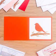 Load image into Gallery viewer, robin aperture on orange card blank
