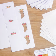 Load image into Gallery viewer, Six A6 printed stocking cut-outs alongside insert papers and envelopes and an iris folding pattern
