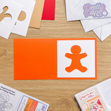 Load image into Gallery viewer, gingerbread man aperture on orange card blank
