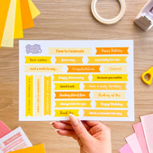 Load image into Gallery viewer, Sheet of decorative sentiments with various phrases on a wooden surface.
